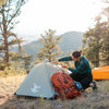 Green Bivy Tent with Rain Fly and woman standing next to the tent in the mountains
