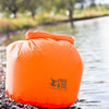 Orange Lightweight Dry Bag Full next to water