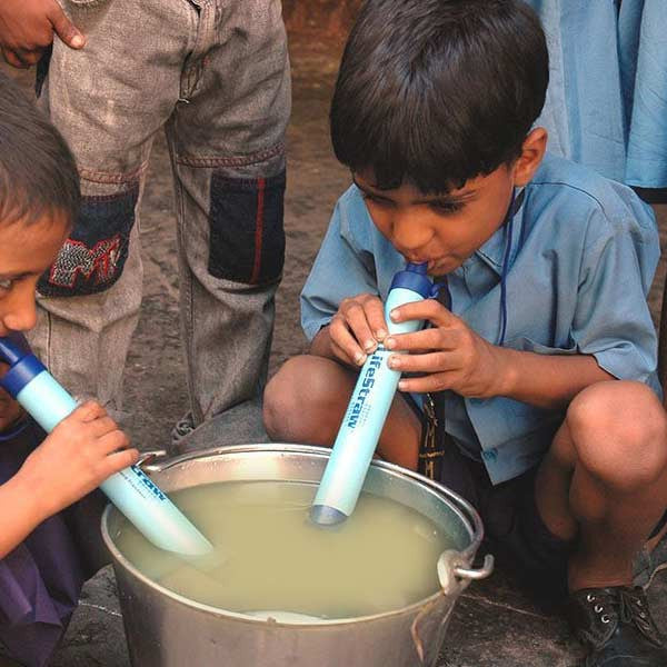 Kids using LifeStraw Personal Water Filters in bowl of dirty water