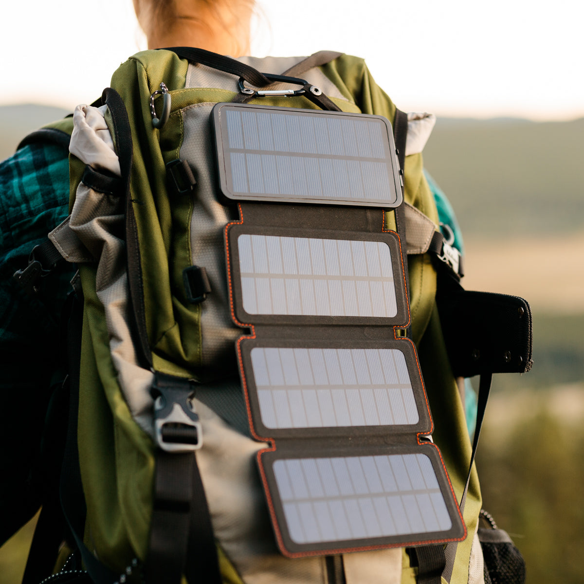 QuadraPro Solar Power Bank Charging in sun clipped to back of backpack